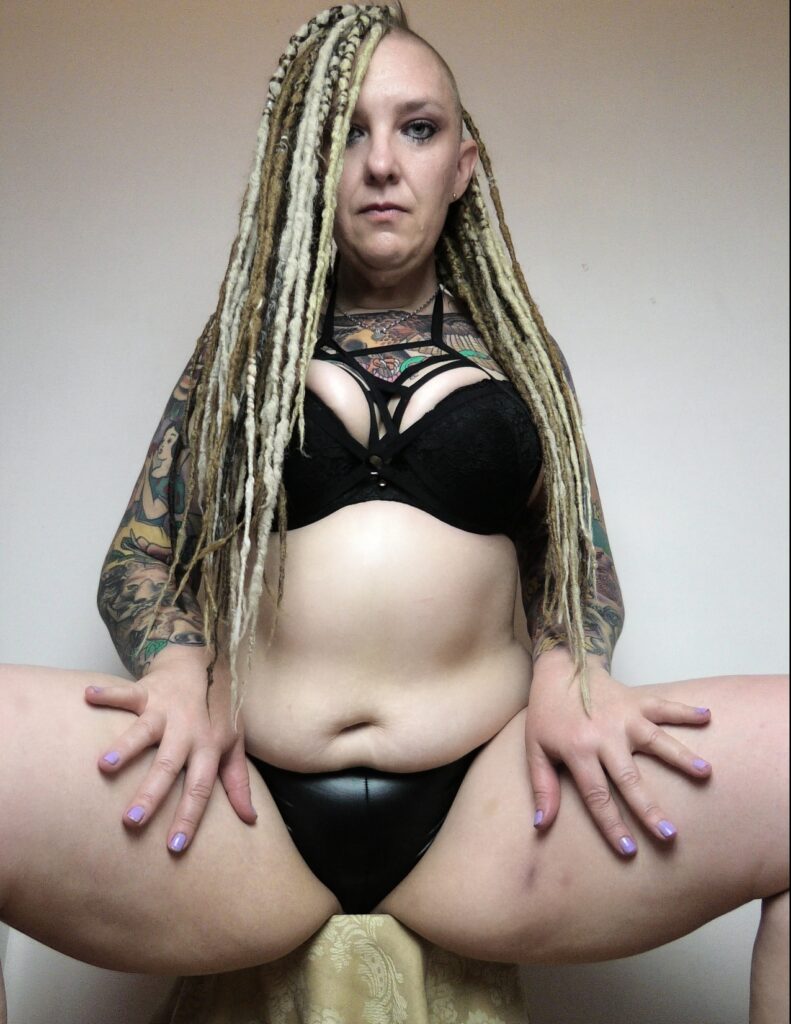Rem Sequence alternative tattooed adult model from Australia sitting with legs spread in black lingerie and dreadlocks